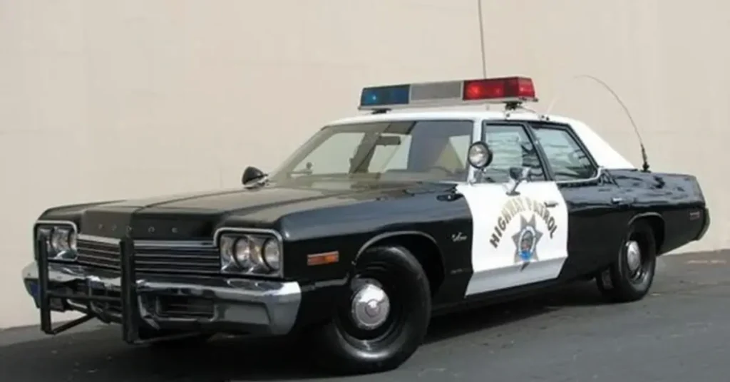 Vintage Police Car standing on the street infront of a beige wall